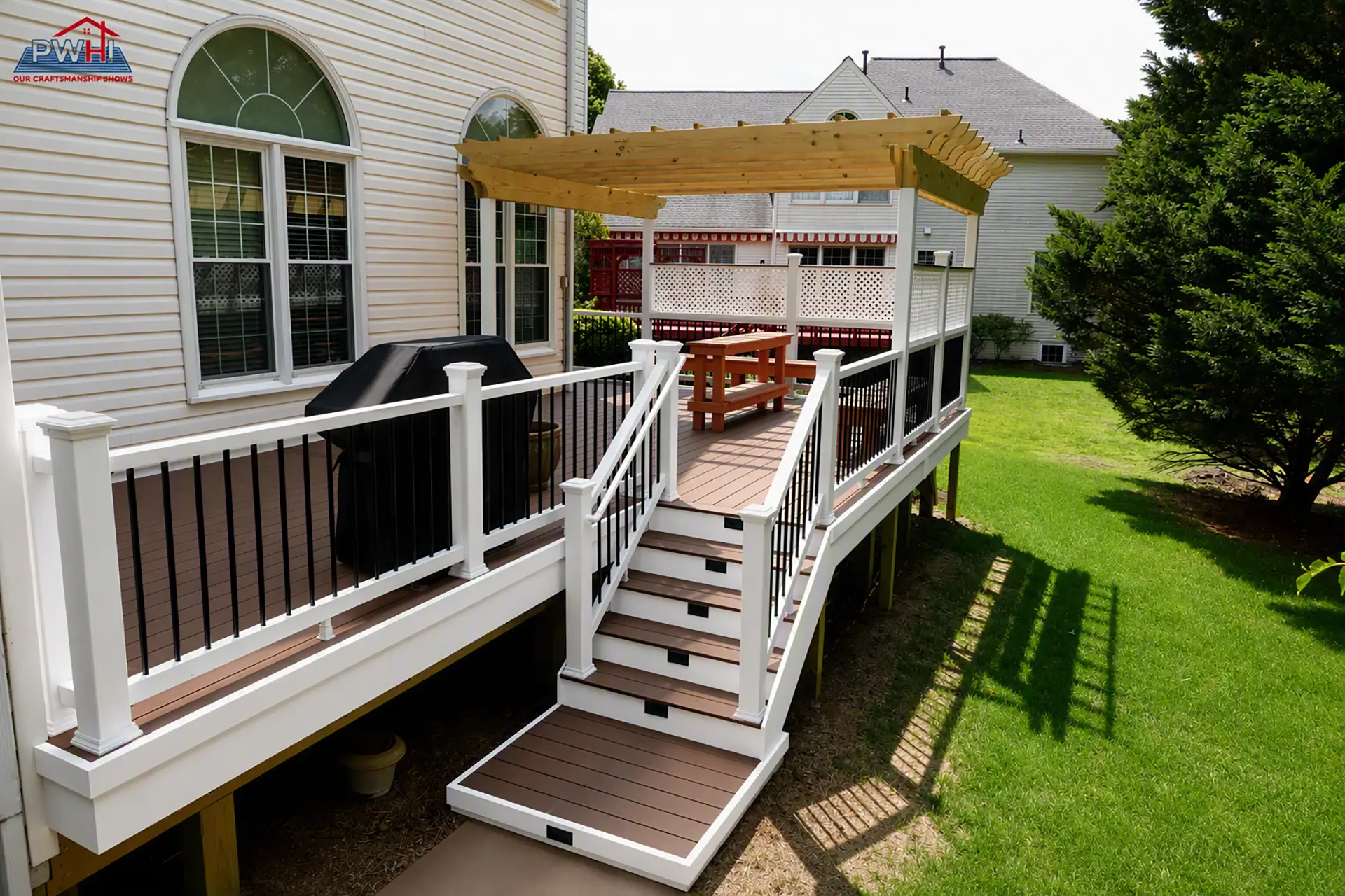 deck construction in gaithersburg md A composite deck attached to a house features a pergola, white railings with black spindles, and a staircase leading to a green lawn.