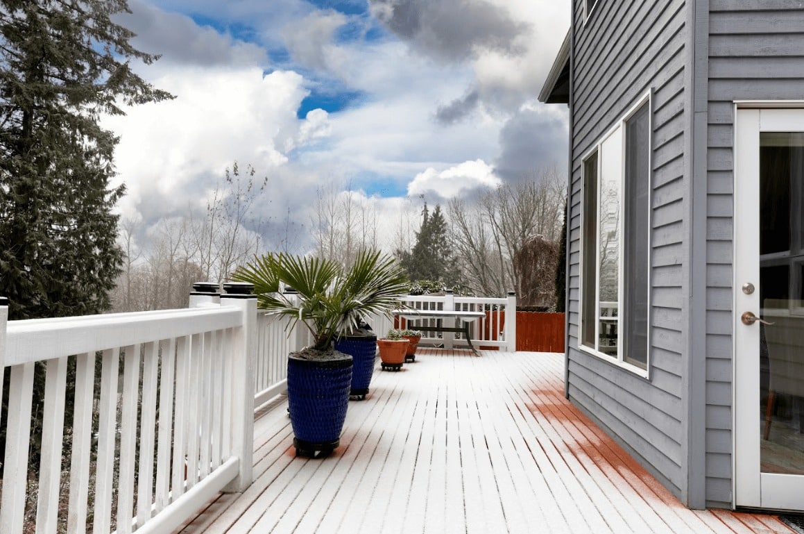 photo of a deck with a light dusting of snow - What Makes a Deck Winter-Resistant - Best Deck builders near me