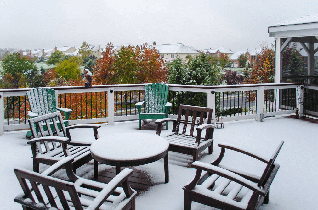 photo of outdoor furniture covered with snow on a deck