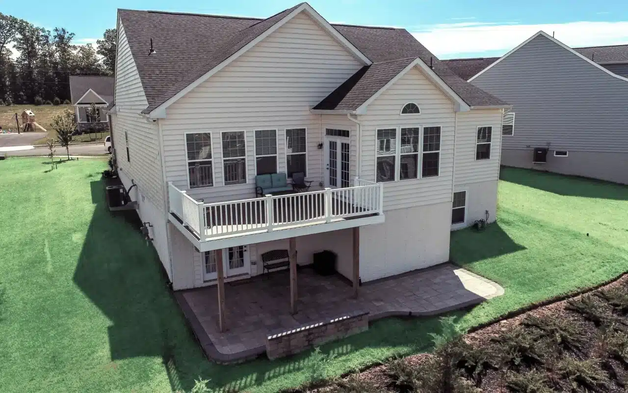 Multilevel backyard patio and deck with a built-in grill station, fire pit, and various seating areas. 