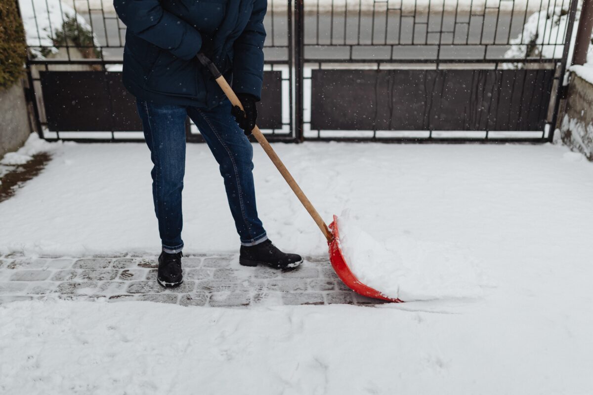 A teenager shoveling a driveway
